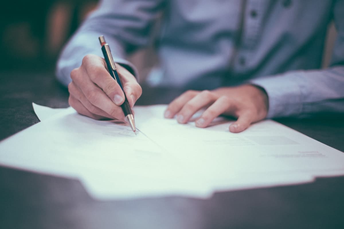 A professional signing a legal document at a desk